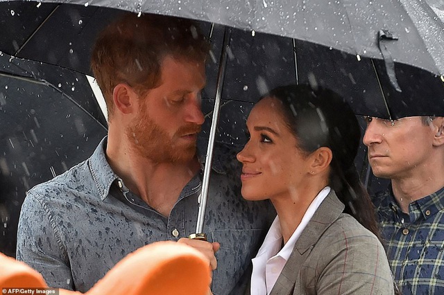  Hoàng tử Harry và cựu diễn viên điện ảnh Meghan Markle cùng che ô đứng dưới mưa 