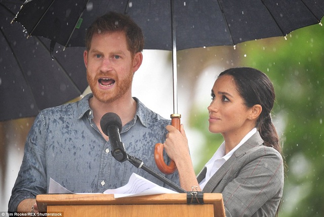  Meghan Markle che ô cho hoàng tử Harry khỏi mưa xối xả khi hoàng tử có bài phát biểu truyền cảm hứng cho nông dân vào ngày thứ hai trong chuyến công du nước Úc. 