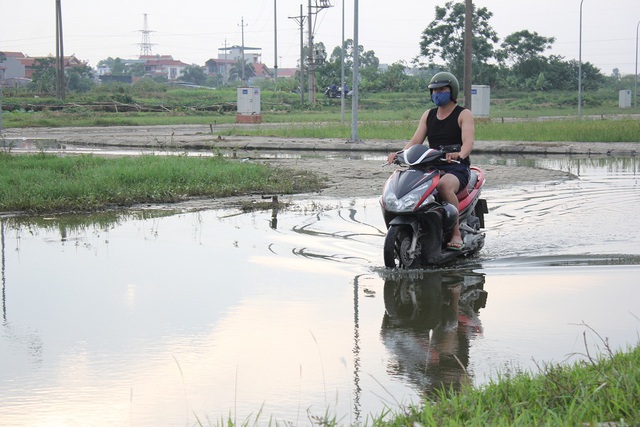 Mực nước ngập cao, bốc mùi hôi thối khiến nhiều người dân phải bịt khẩu trang khi di chuyển