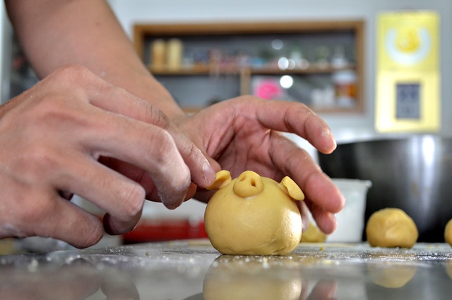 Thợ bánh đang tạo hình chú heo con, một sản phẩm độc đáo của của chị Linh.