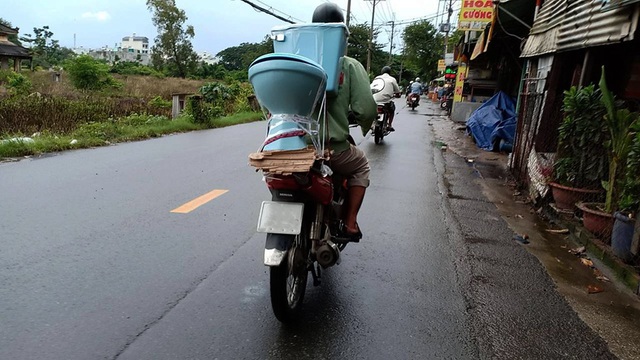 Một khách hàng đang vận chuyển chiếc bồn cầu vừa chọn được, hình ảnh khá quen thuộc trên cung đường này