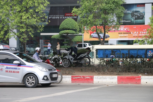 Gầm cầu vượt vành đài 3 (đường Phạm Hùng, Hà Nội) là nơi được nhiều người lựa chọn nghỉ ngơi buổi trưa. Sở dĩ gầm cầu trở thành nơi mát mẻ vì vừa thoáng gió, vừa có cầu che nắng bên trên và thảm cỏ xanh mát phía dưới khiến cái oi bức cũng dịu bớt.