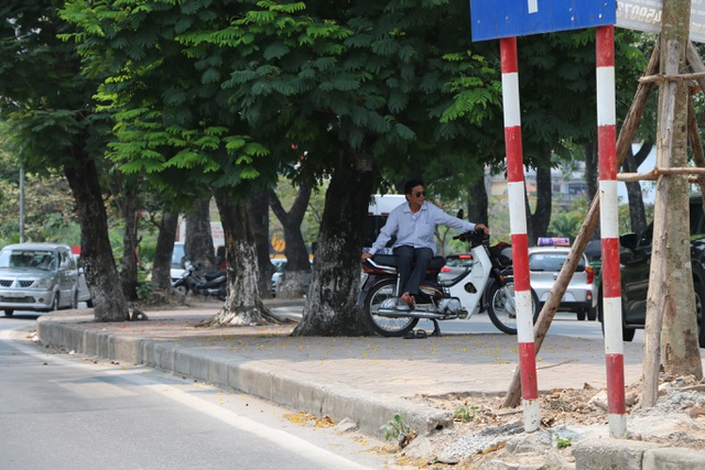 Chú xe ôm này cũng chọn cho mình chỗ đứng dưới tán cây rộng trên vỉa hè, tranh thủ nghỉ ngơi cũng như đợi khách đi xe ôm.