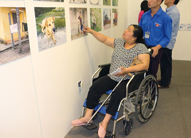 Chị Phạm Thị Hoa (Thái Nguyên) đang giới thiệu 1 trong số 17 bức ảnh chị chụp tại triển lãm.