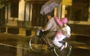 Ảnh “cháu gái dùng ô che mưa cho ông” gây xúc động dân mạng