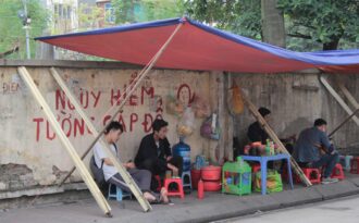 Liều mình ngồi bán hàng dưới bức tường “tử thần” ở Hà Nội