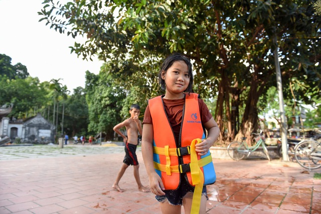  Một số em nhỏ mặc áo phao khi bơi hồ, nhưng cũng có em không mặc. 