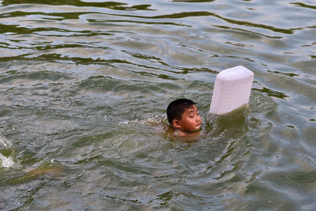  Một em nhỏ dùng can làm phao bơi. 