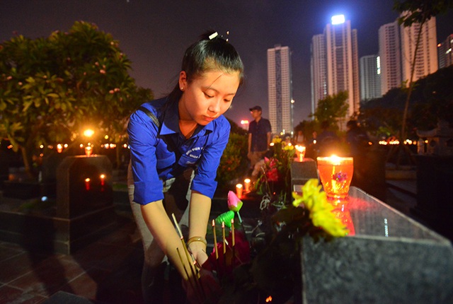 Bạn Đinh Thu Uyên (sinh viên năm 2 Đại học Thương Mại) thành kính dâng hương, thắp nến tri ân tại nghĩa trang Mai Dịch.