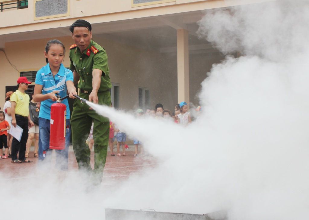 Các cháu học sinh được cán bộ Phòng PCCC số 1 - Cảnh sát PCCC Nghệ An giới thiệu về các phương tiện chữa cháy.