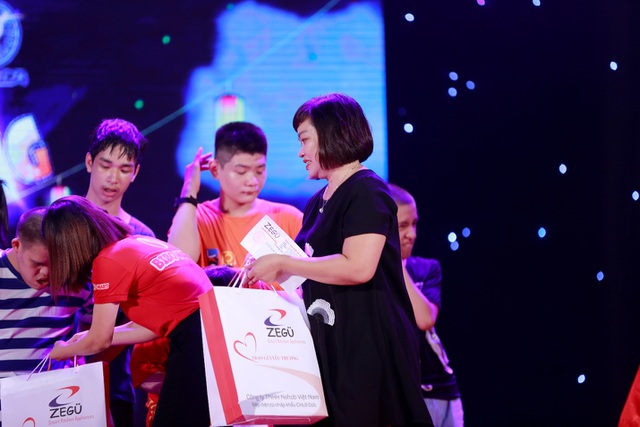 Bà Trương Thị Thùy Ninh (áo đen) trao quà cho các em nhỏ tại chương trình.